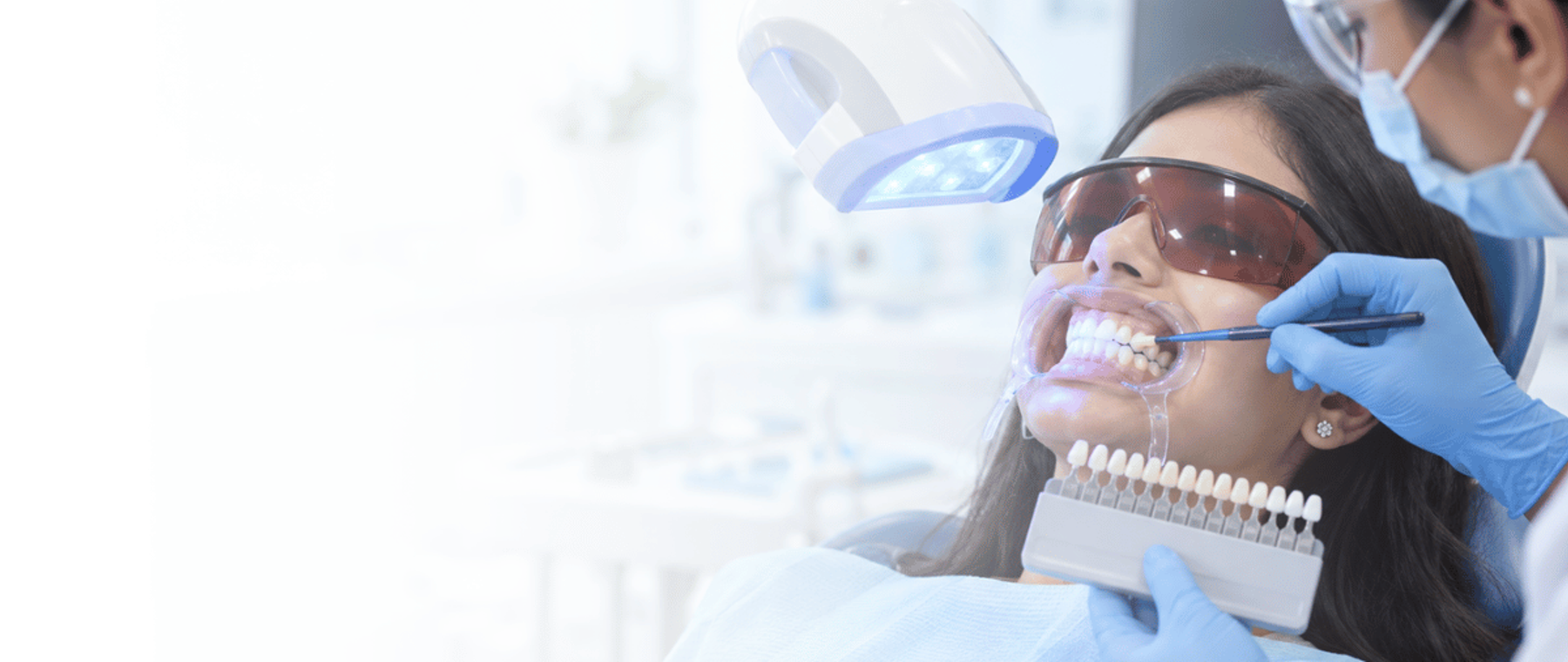 Teeth whitening in Karachi: patient having professional in-clinic whitening with a shade guide held up