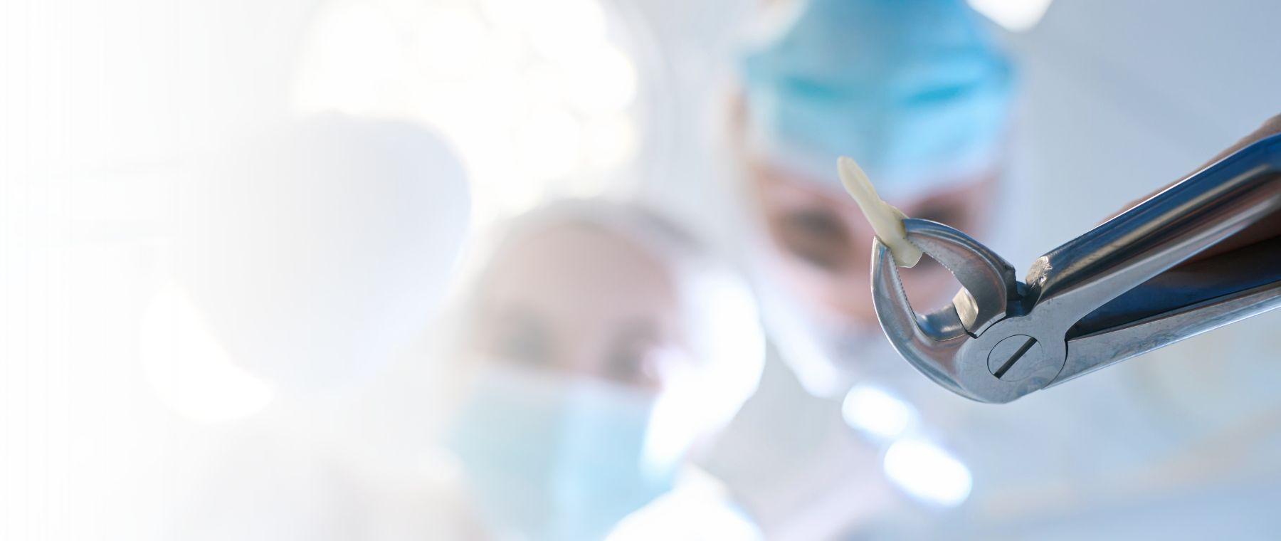 Wisdom tooth removal in Faisalabad, dental forceps held by a surgeon at DentoCorrect
