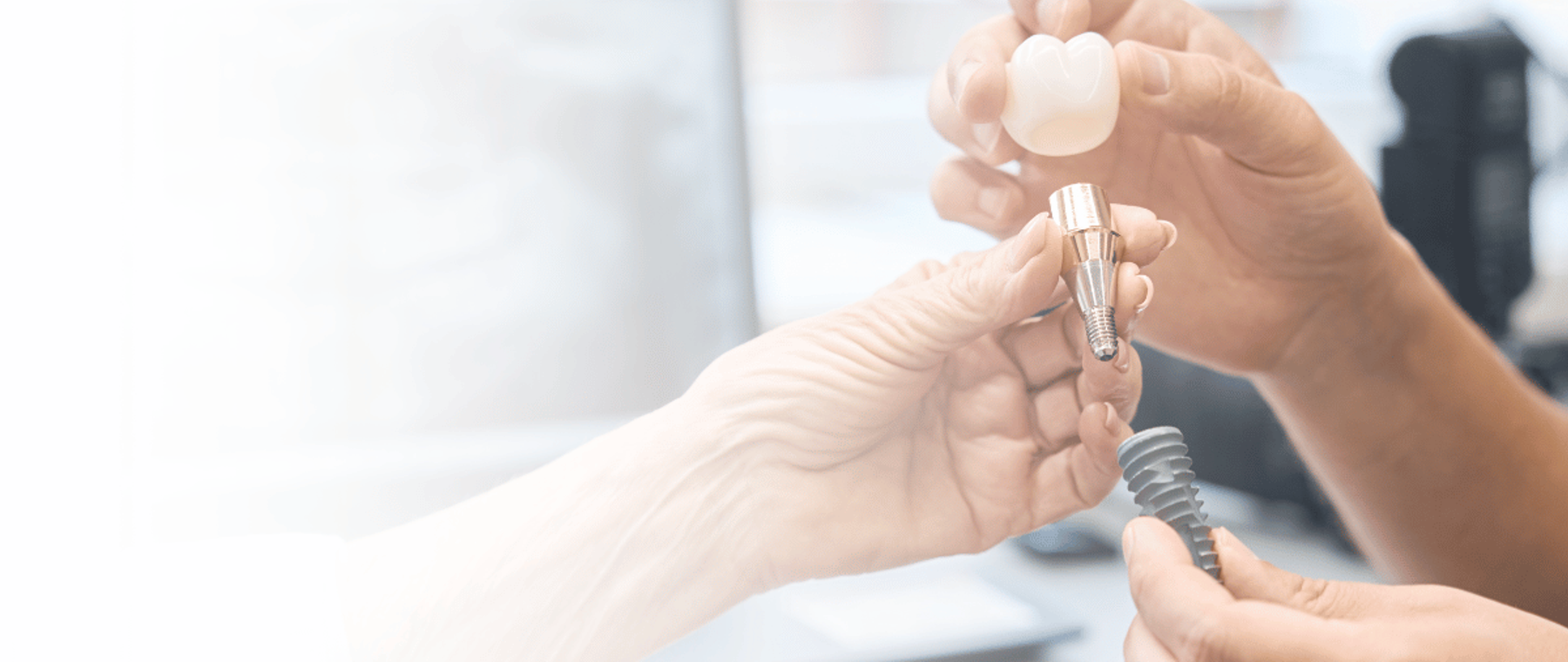 Dentist holding a dental implant and crown in Faisalabad at DentoCorrect