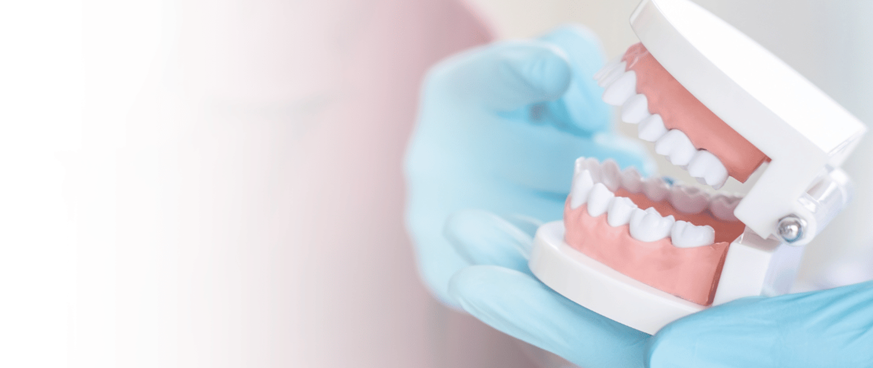 Dentist holding a set of complete dentures in Karachi at DentoCorrect