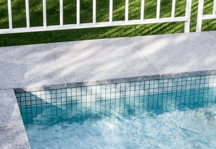 Close up of pool tile and white steel pool fence