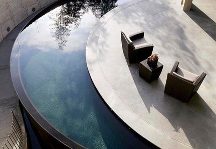 Curved pool around outdoor sun bathing area