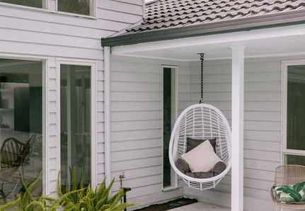 Hanging egg chair in corner of outdoor garden near pool