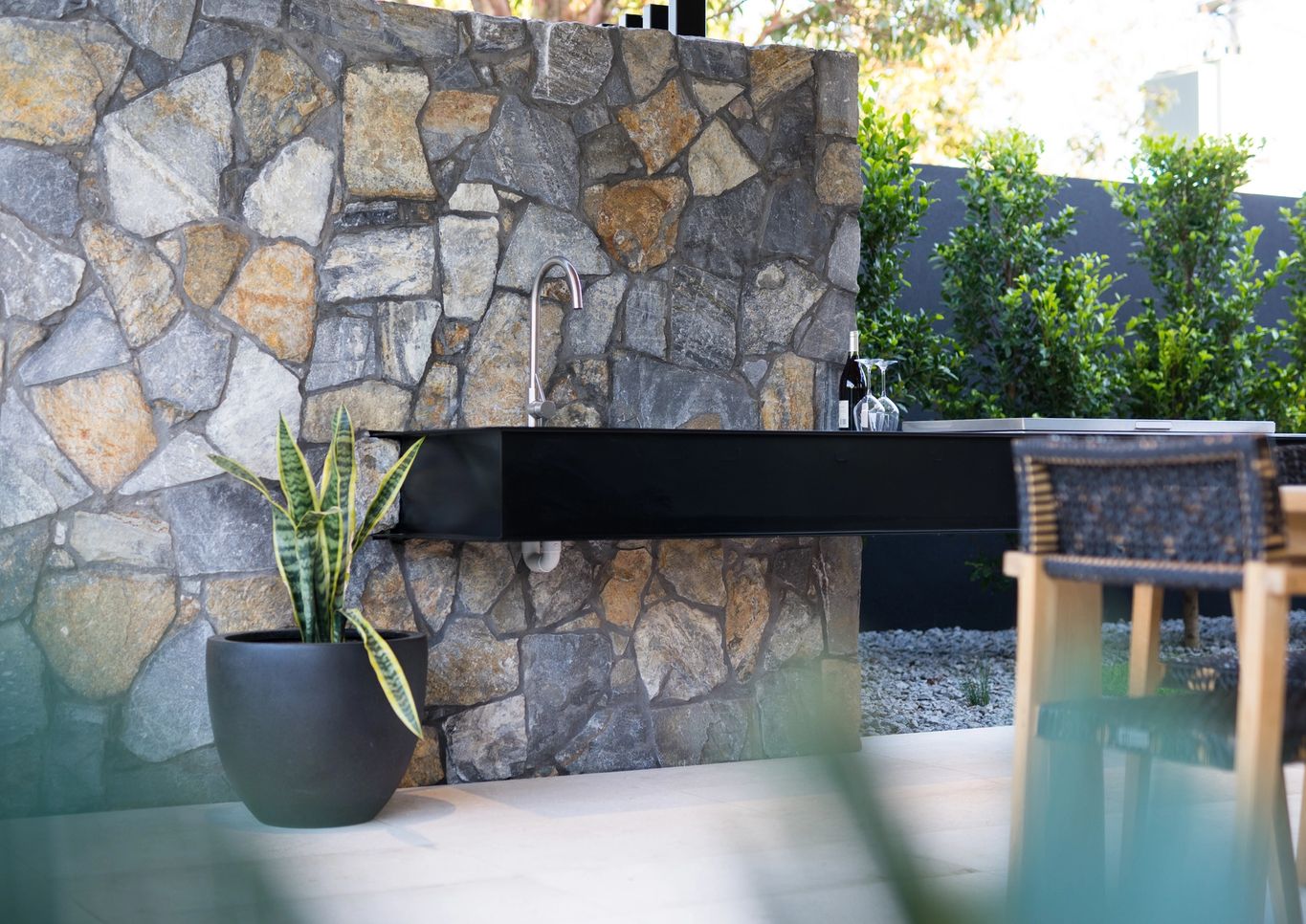floating outdoor bench with sink and stone wall