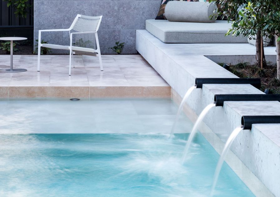 Water spouts into pool looking to day bed area and Cosh Living furniture