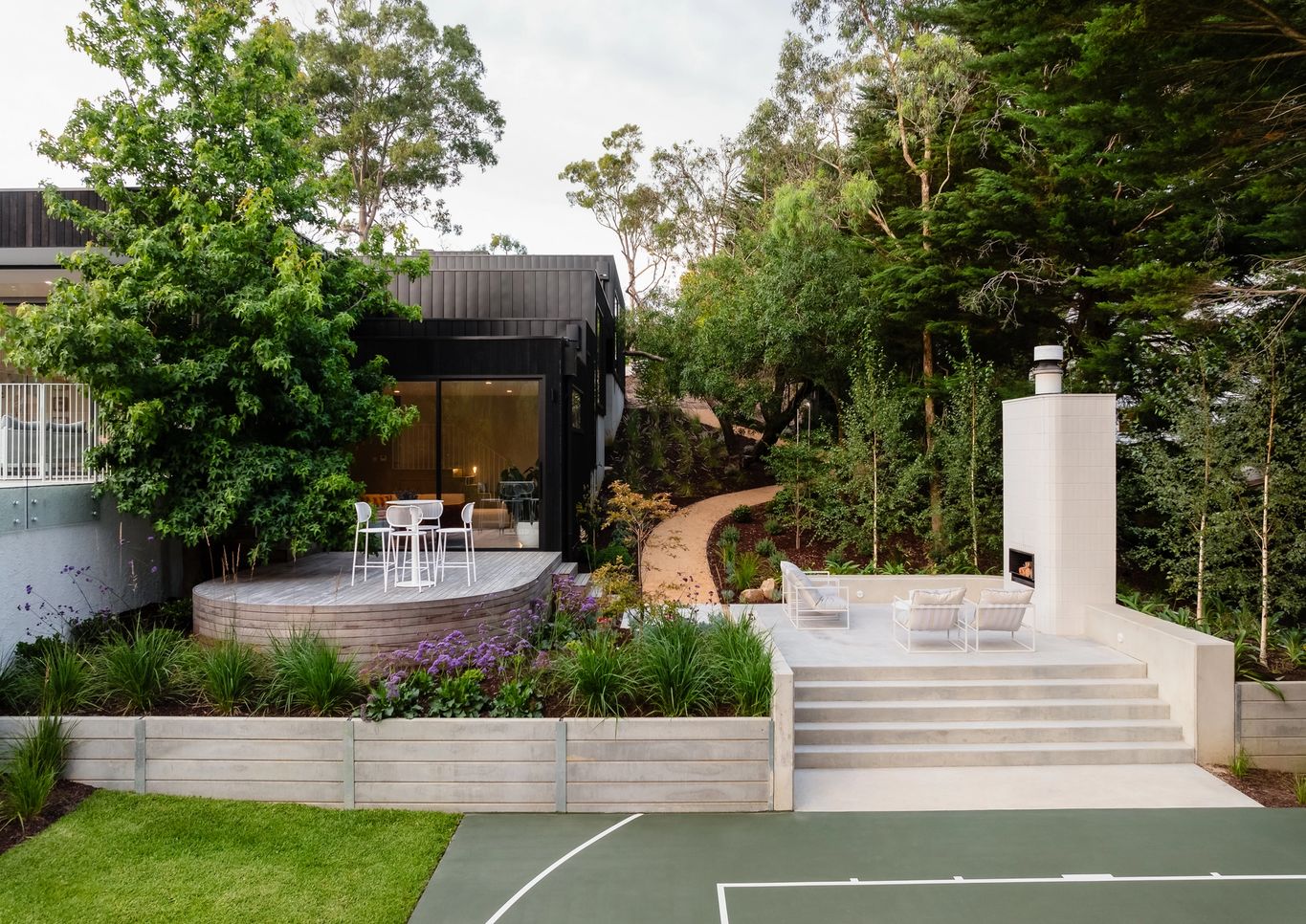 Raised Outdoor fireplace near curved deck and basketball court