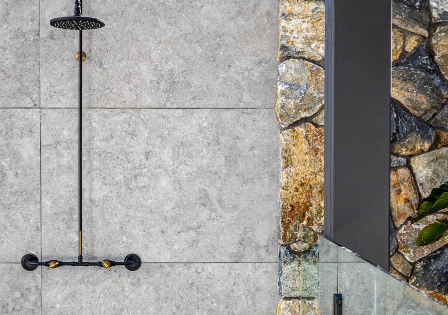 Rock clad wall and tiles in landscape design by Mint Pool and Spa, Melbourne