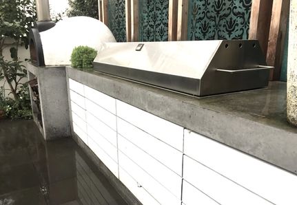 custom designed outdoor grill with removable rotisserie arms and hood with a concrete benchtop