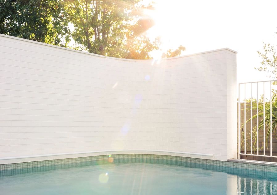 Mineral Magnesium Pool example with a curved brick white wall around pool