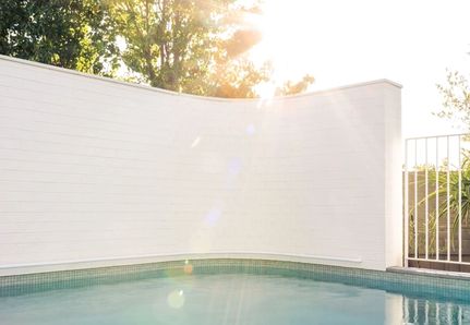 Curved white wall around pool