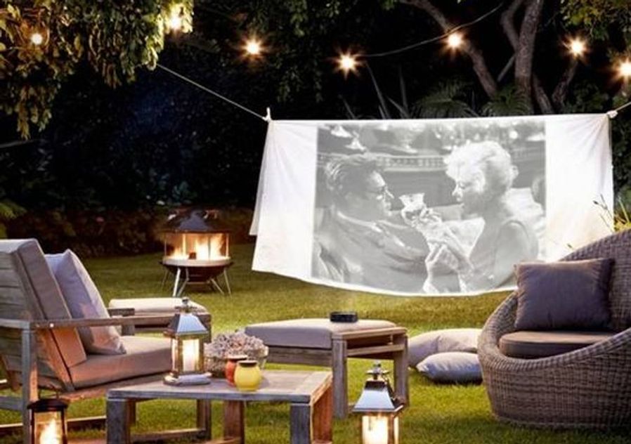 Outdoor cinema screen at home with snacks and wine