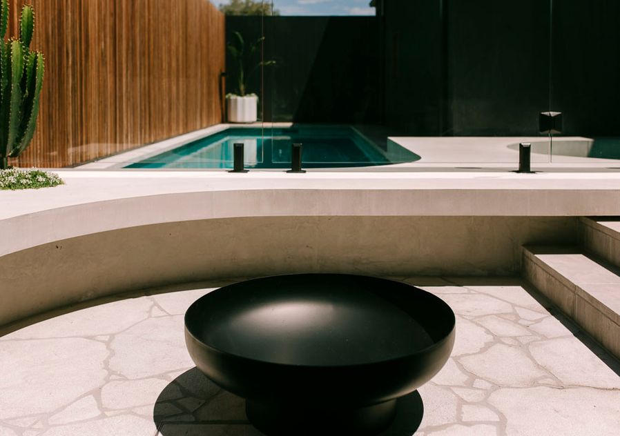 Sarita Holland and Brodie Holland backyard firepit and pool with curved concrete benchseat