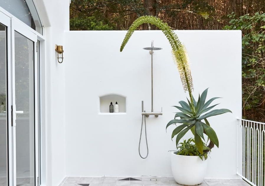 Outdoor shower against white wall