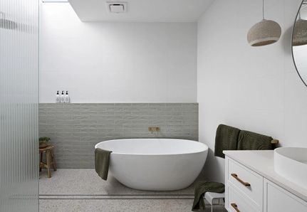 Bathroom with bath and modern tiles at Parkview House by Allie Harris and Mint Design