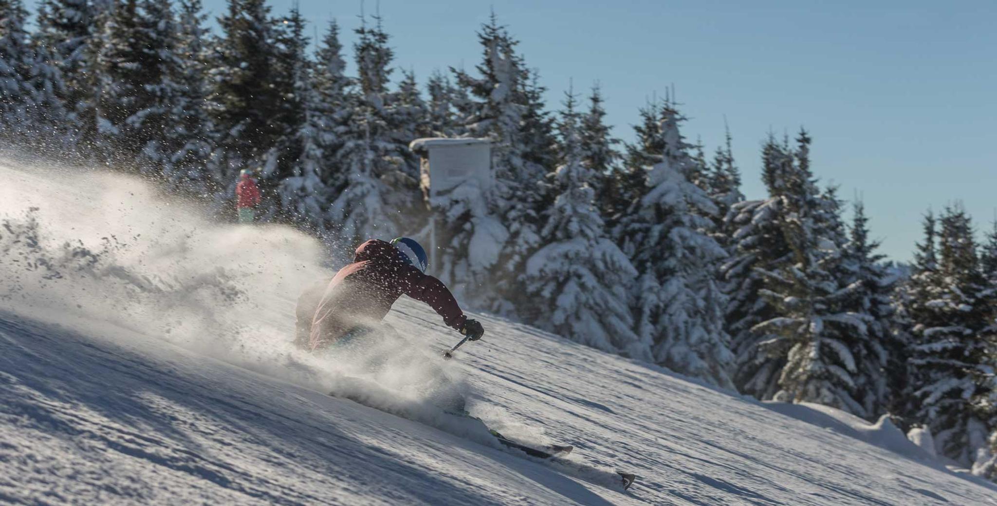 Skifahrer fährt schnelle eine Piste hinunter