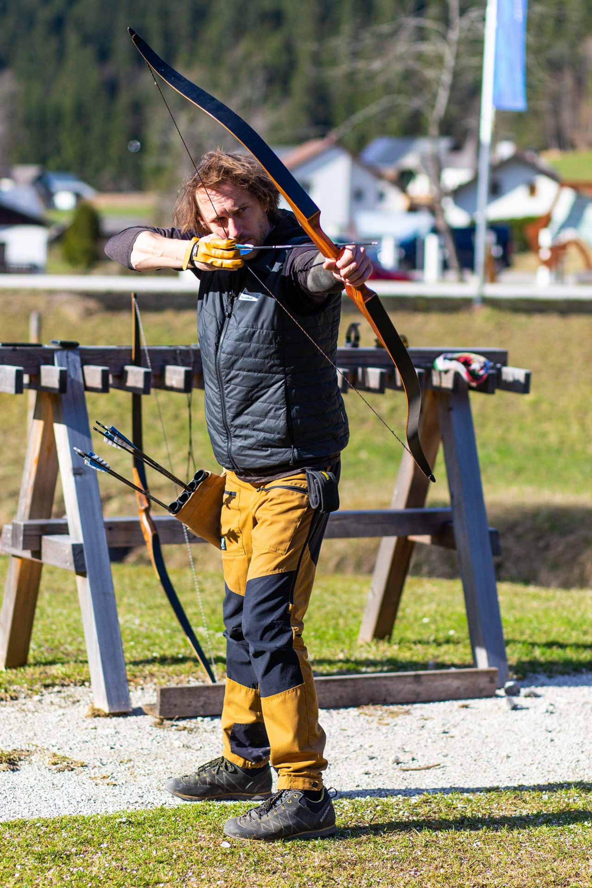 Guide Hannes hält Pfeil und Bogen in der Hand und zielt 