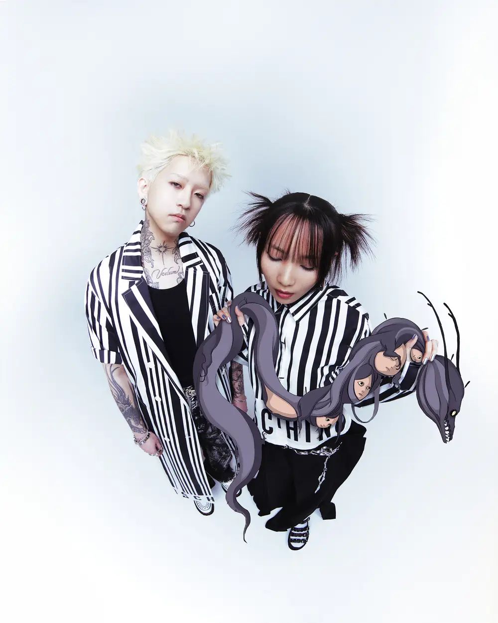 Two tattooed people in black-and-white striped outfits pose with an illustrated purple serpent.