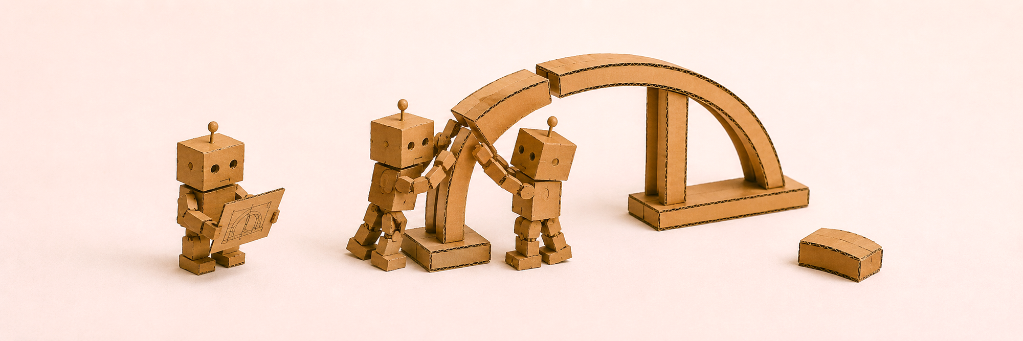 Cardboard robots building a bridge together from a plan