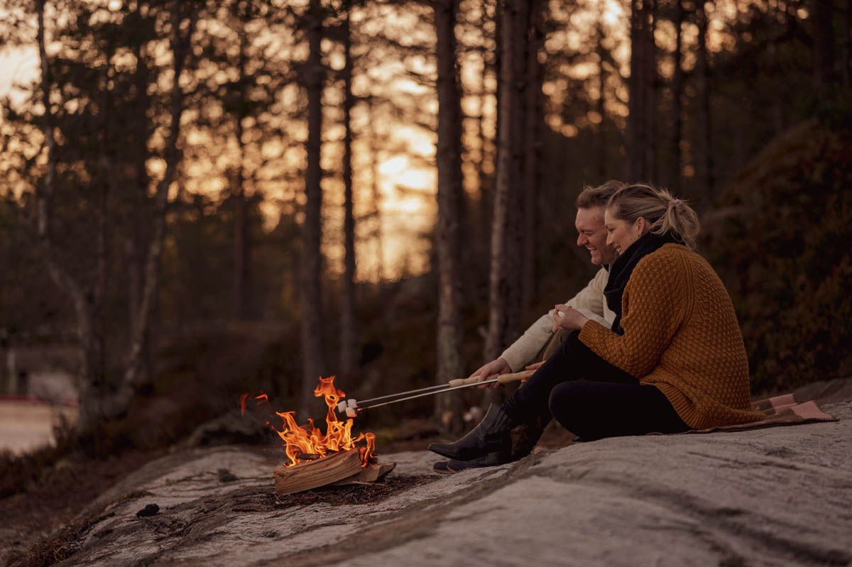 Fotostorie, kjærestepar på svaberg foran bålet i skumring