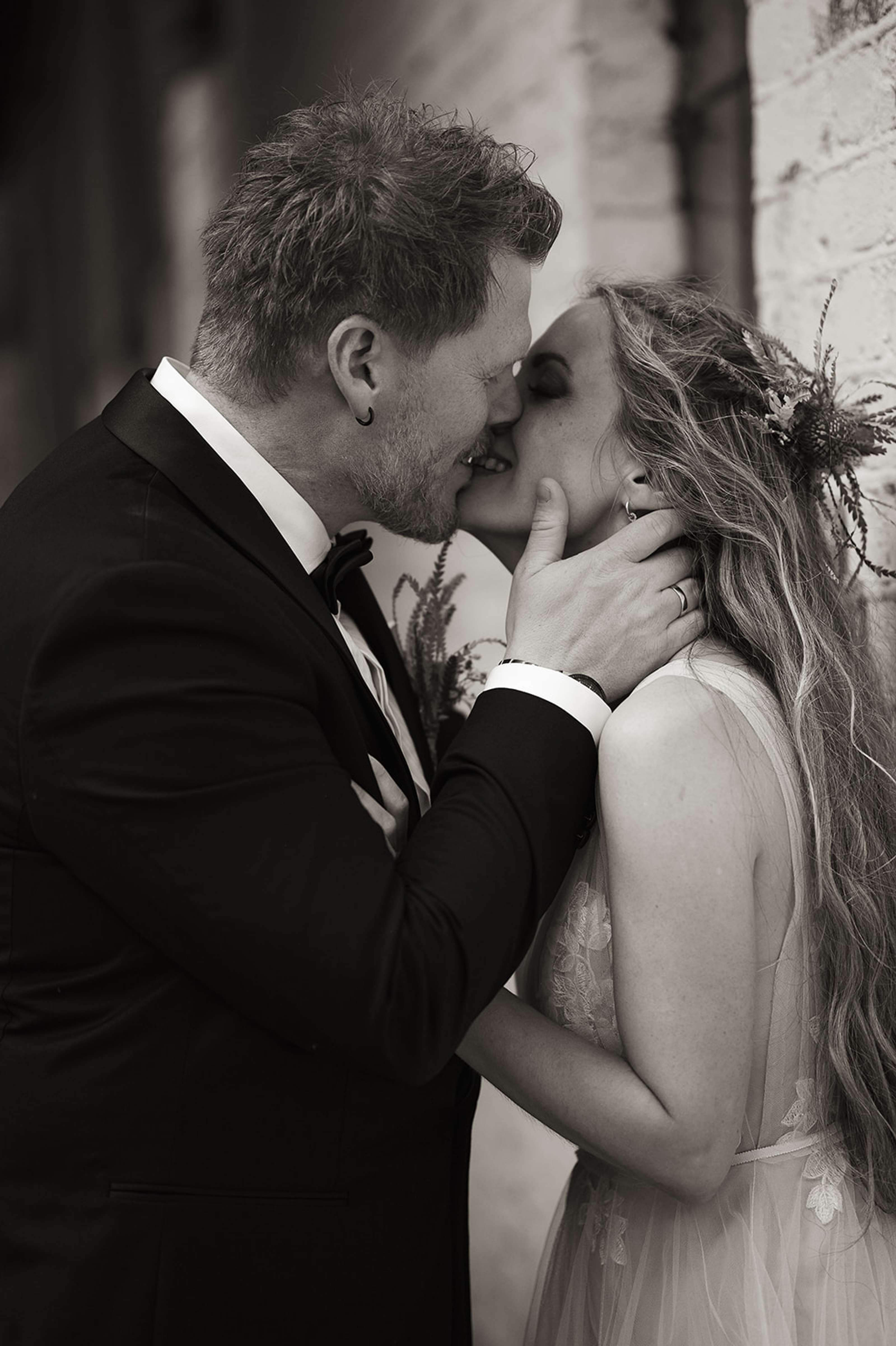 Brudepar som kysser under ei bru