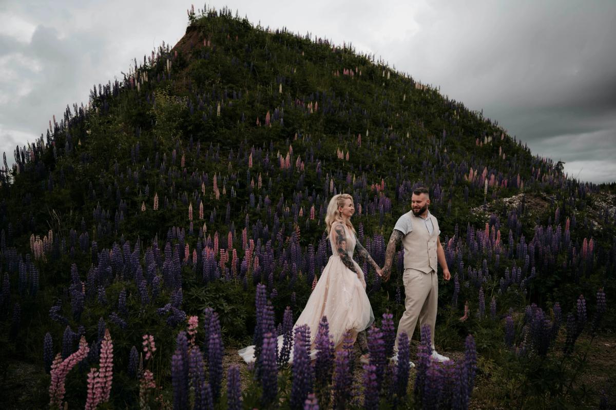 Bryllupsfotografering av nygift par i blomstereng