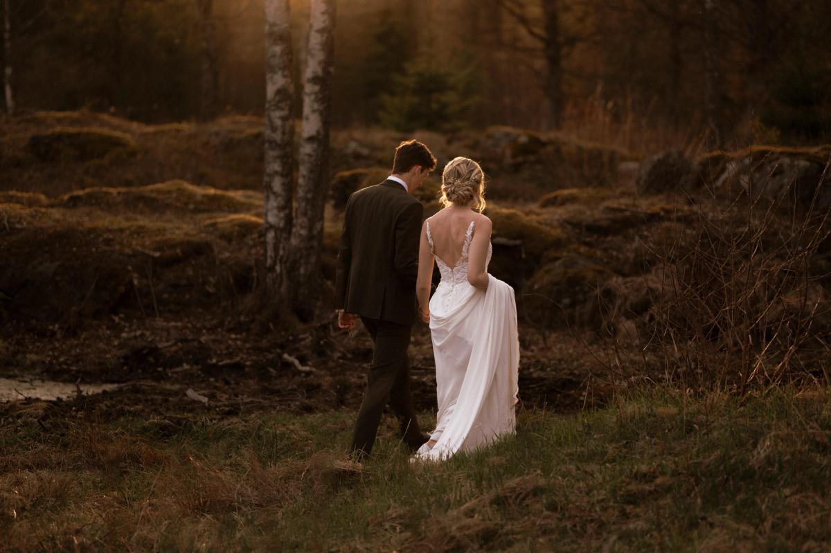 Forelsket brudepar på bryllupsdagen foreviget av bryllupsfotograf i solnedgang i Oslo Lillestrøm