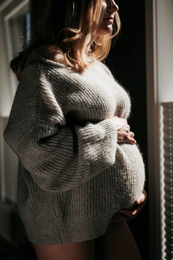 Gravid kvinne ved vinduet