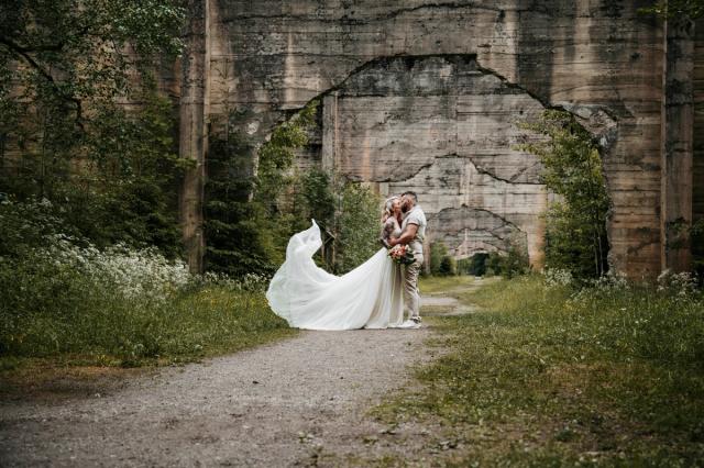 Bryllupsfotografering av Fotostorie - Brudepar ute i naturen og brud med kjole som flagrer