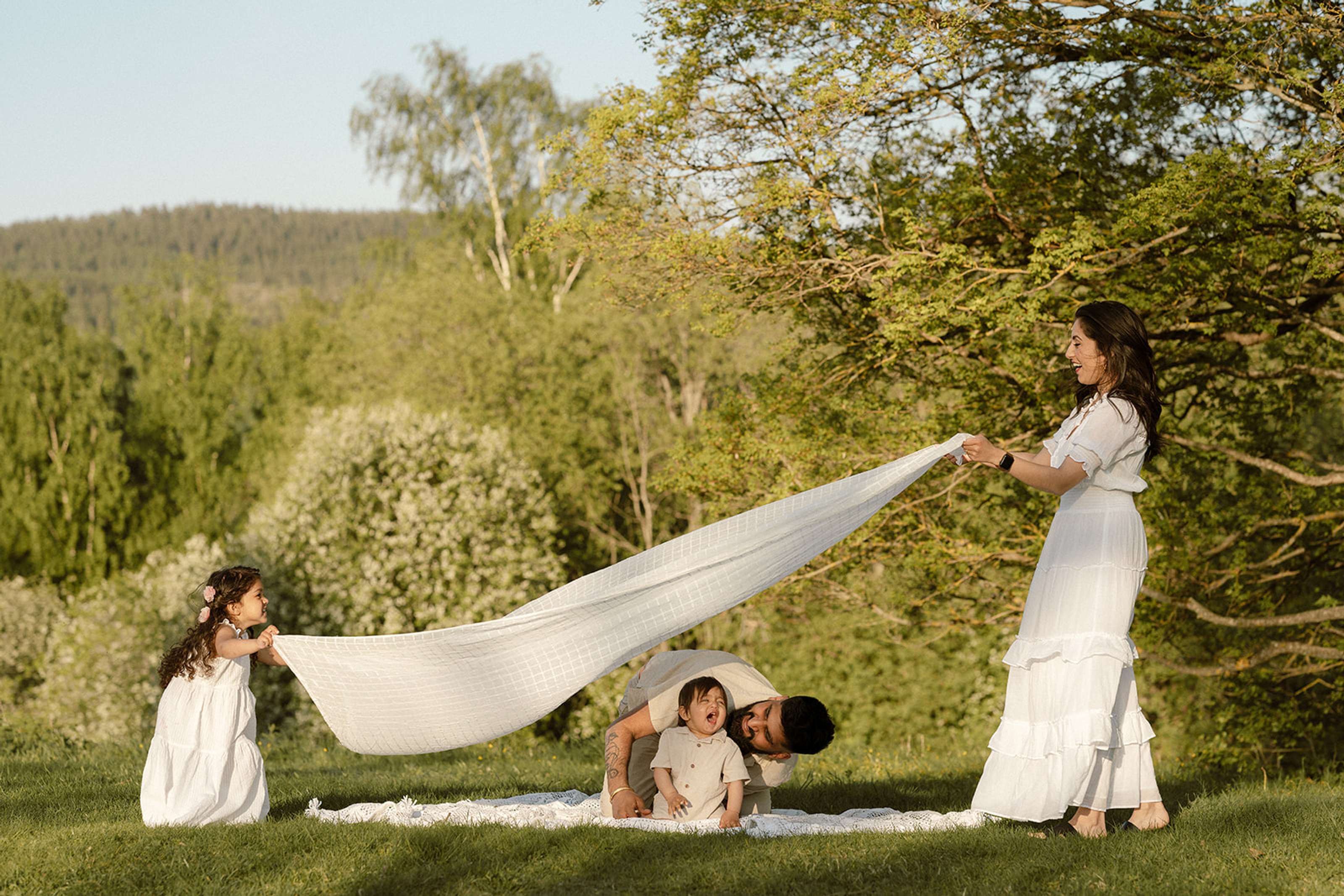 Familie som leker ute i solnedgang