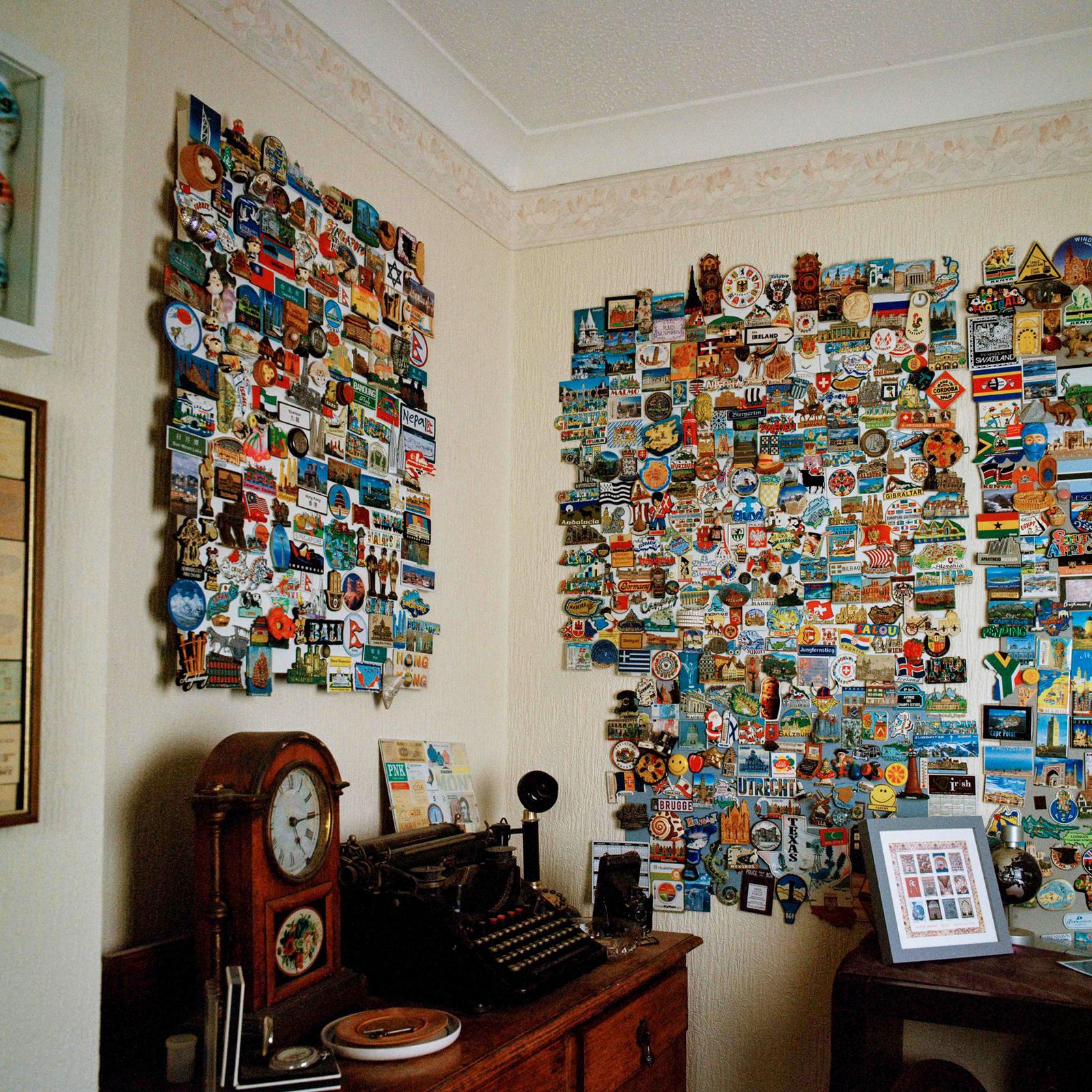 Various postcards, stickers, and small items displayed on a wall and a nearby table.