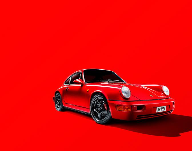 A red sports car, specifically a Porsche 911, is the main subject of the image.