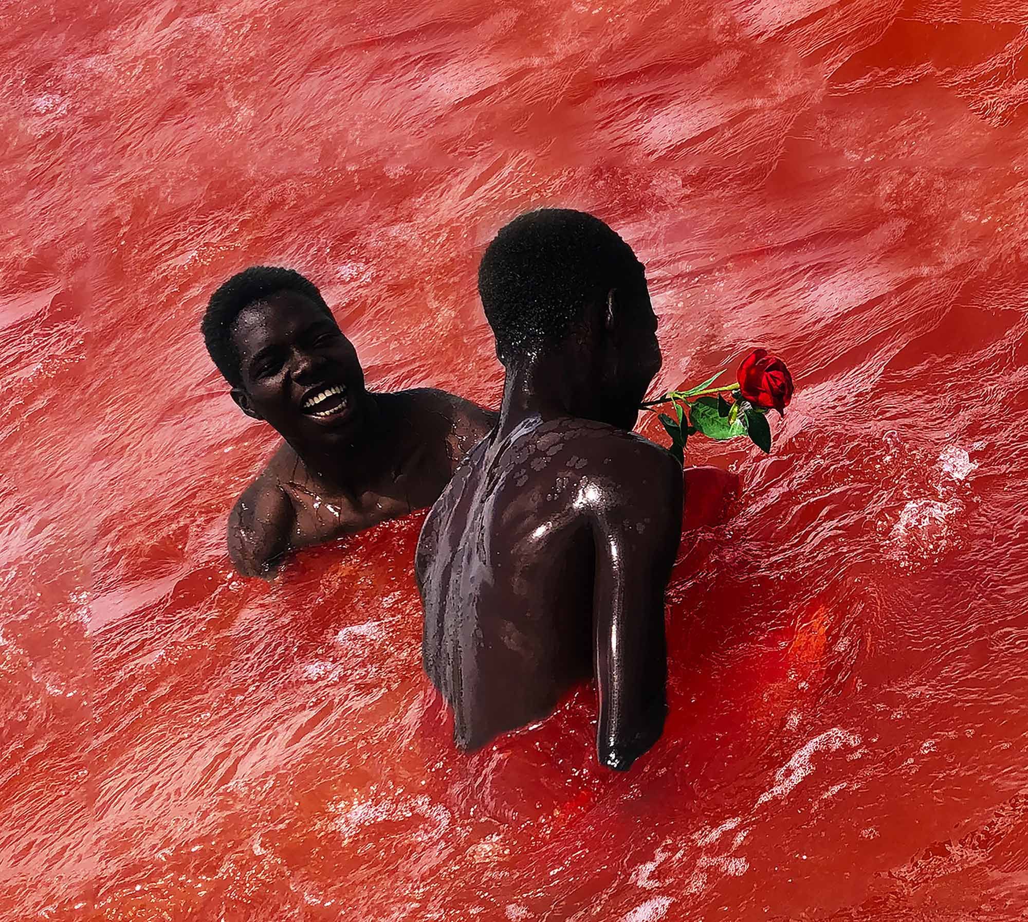 Two black children in a red, murky water body, one holding a red rose.