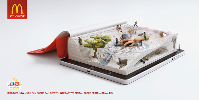 A McDonald's advertisement featuring a 3D book with people and trees on a tablet screen.