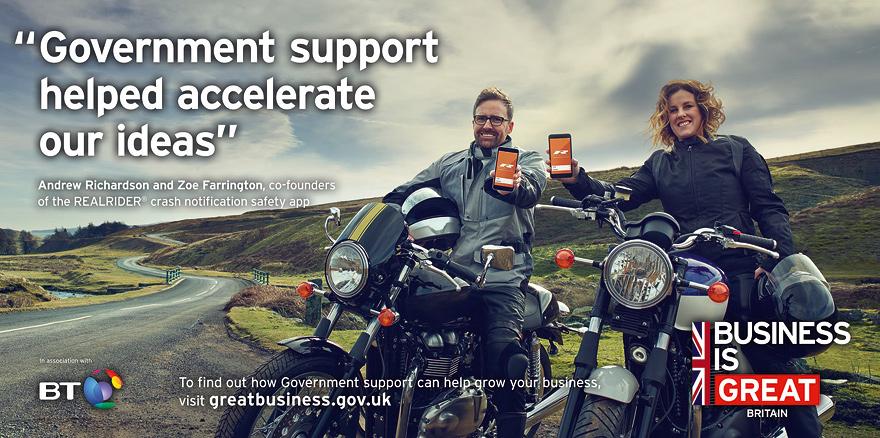 A man and a woman in business attire standing in front of a landscape, holding up mobile devices displaying a 'Business is Great' logo.