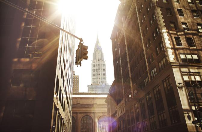 A city street in New York City, with the iconic Empire State Building in the background.