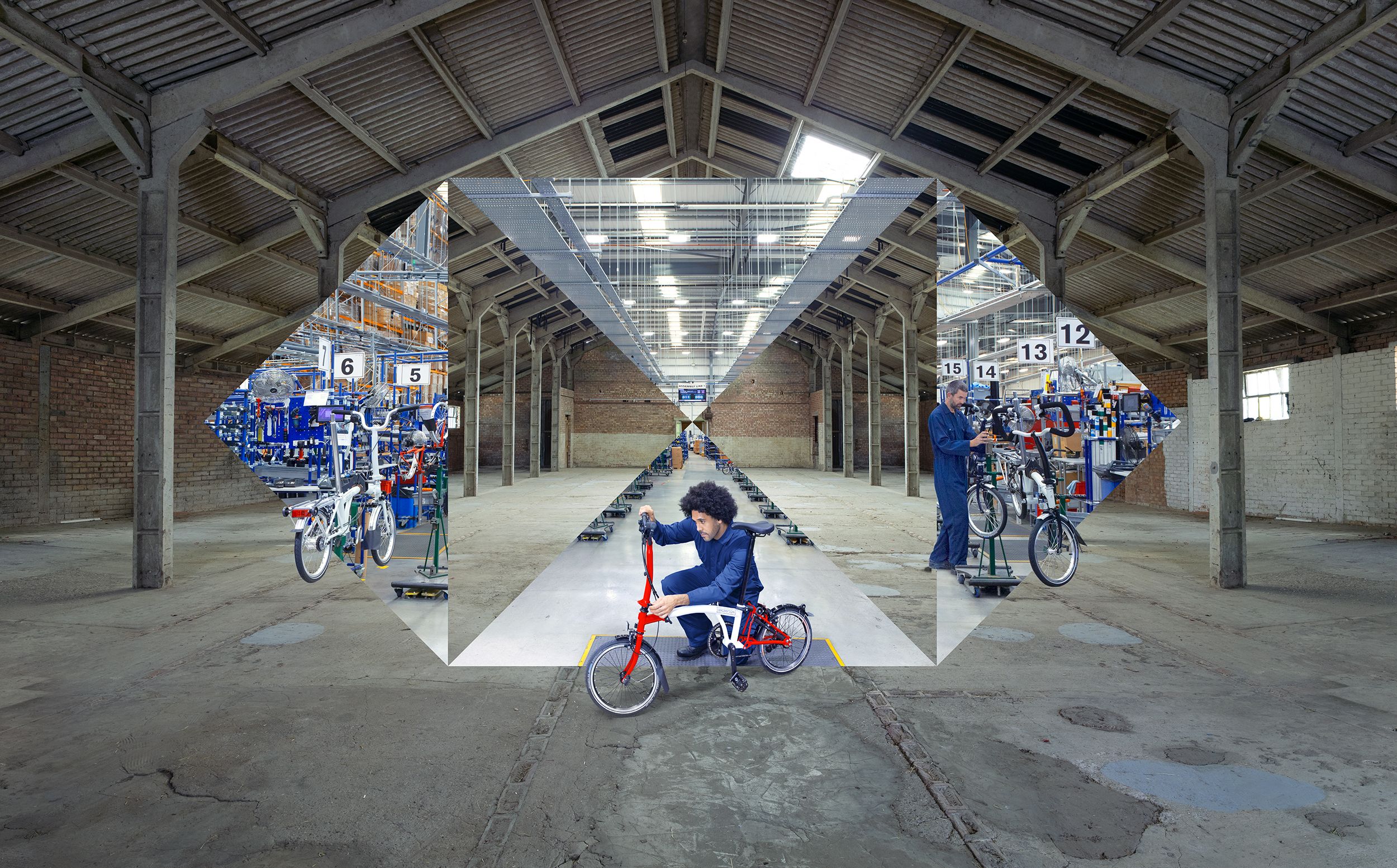 A man in a blue jumpsuit is riding a red and white bicycle in an empty warehouse.