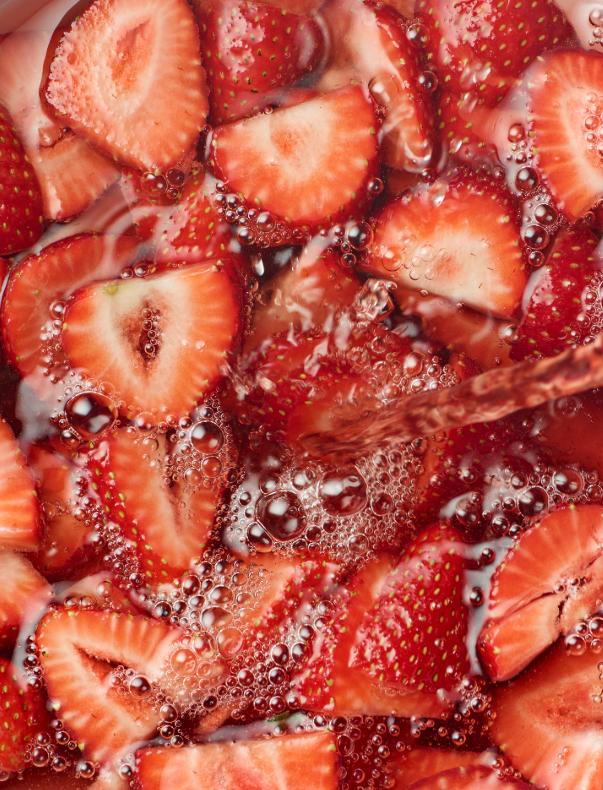 A close-up of sliced strawberries in a bowl, likely for a food or dessert photography project.