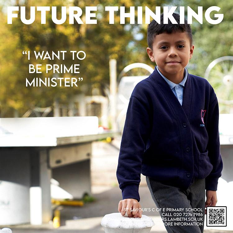 A young boy in a school uniform is standing in front of a school building, looking directly at the camera with a serious expression.