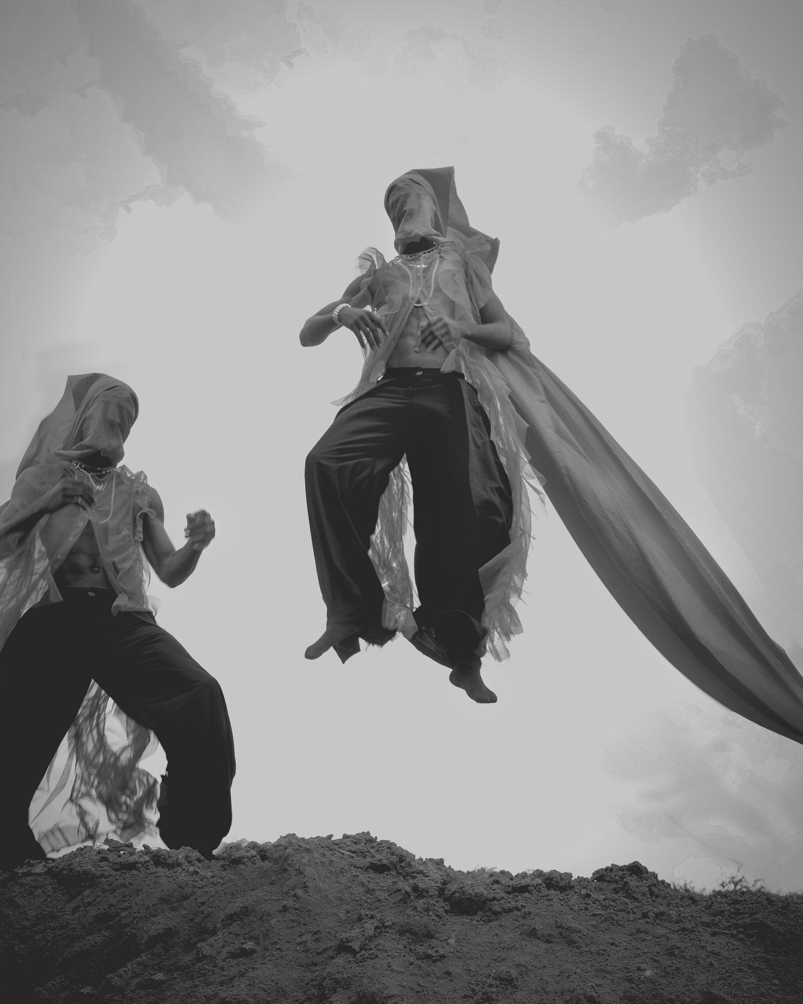 Two people performing a dance in a desert landscape.