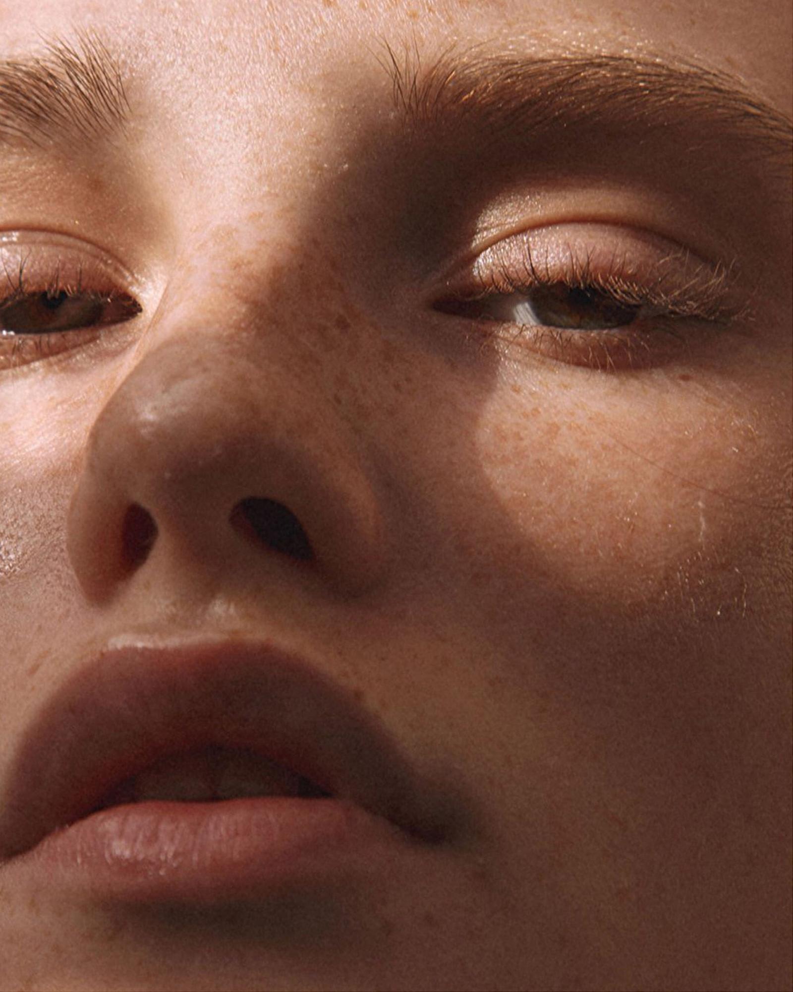 A close-up of a person's face, with a subtle, naturalistic lighting effect.
