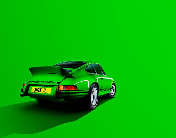 A bright green 1974 Porsche 911 with a distinctive rear spoiler and a license plate reading 'MRX IL'