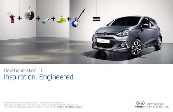 A car in a large, empty room with a few objects hanging from the ceiling, including a guitar, a skateboard, and a few other items.