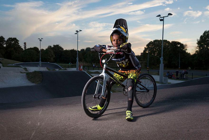 A young boy on a bike at a skate park, wearing a helmet and a bike jacket.