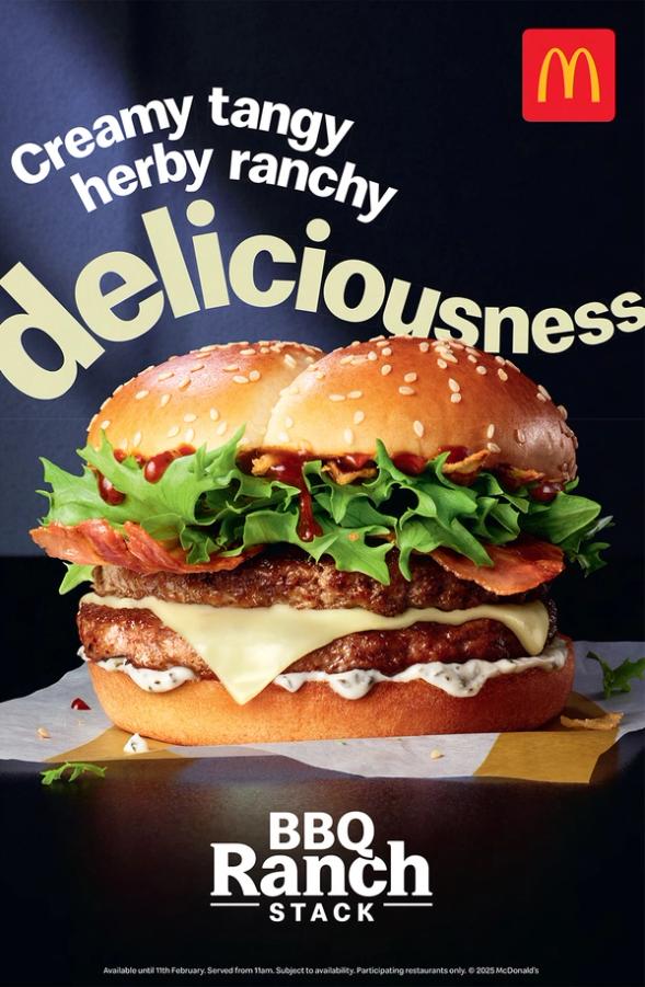A large, juicy burger with a beef patty, cheese, lettuce, tomato, and a sesame seed bun, sitting on a paper wrapper with a red and yellow McDonald's logo in the top left corner.