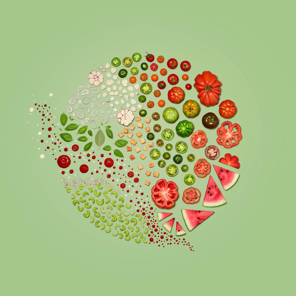 A vibrant, colorful arrangement of various fruits and vegetables, including tomatoes, watermelon, and other produce, arranged in a creative and artistic way.