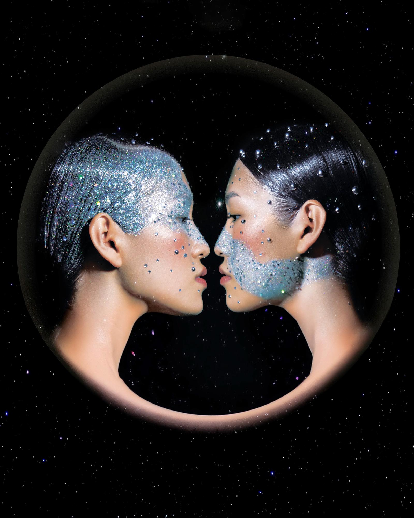 Two women in a mirrored sphere, surrounded by a galaxy of glittering stars and cosmic dust, their faces and bodies reflecting the beauty of the universe.