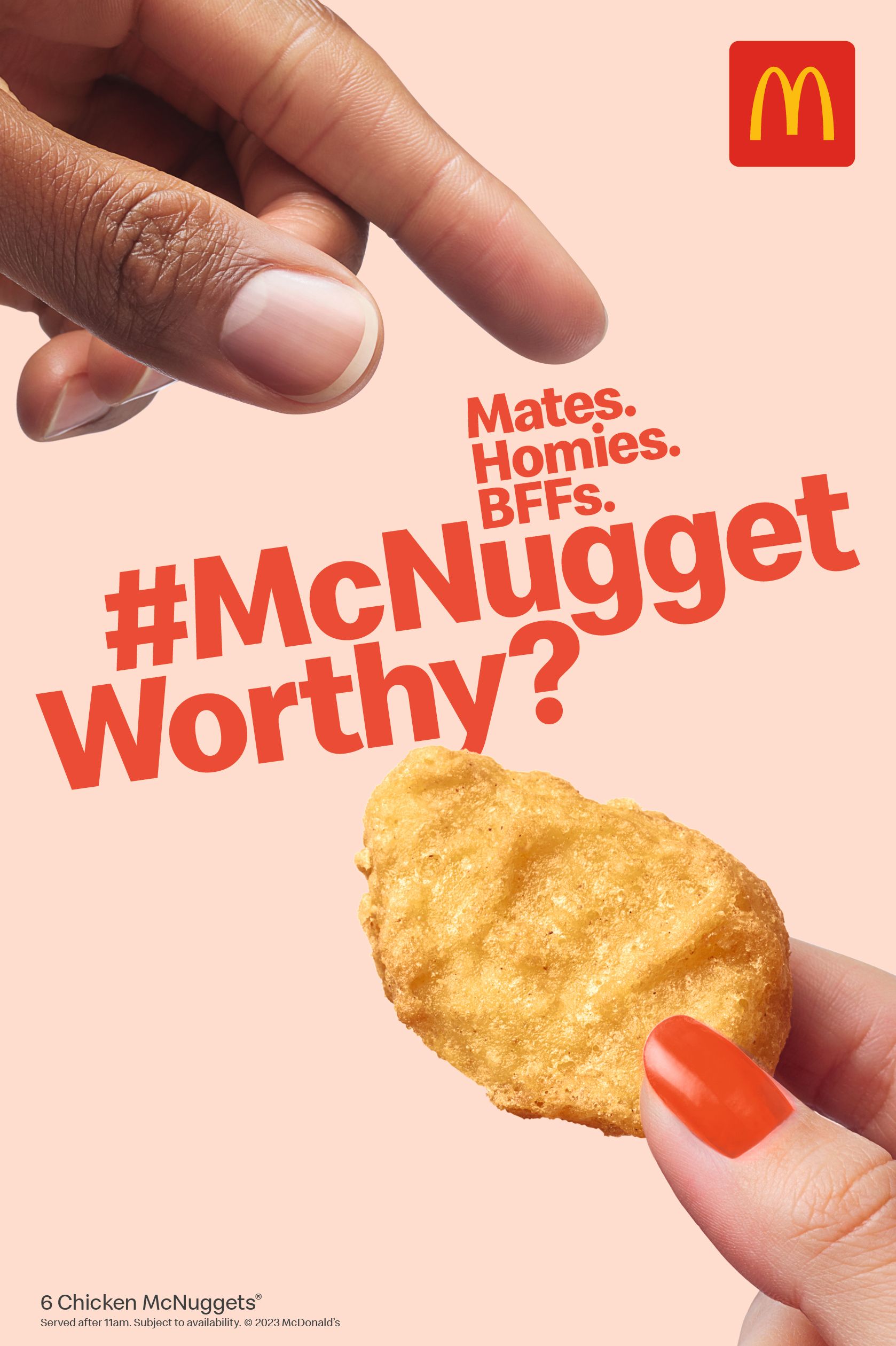 A hand holding a McNugget, with a finger pointing at it.