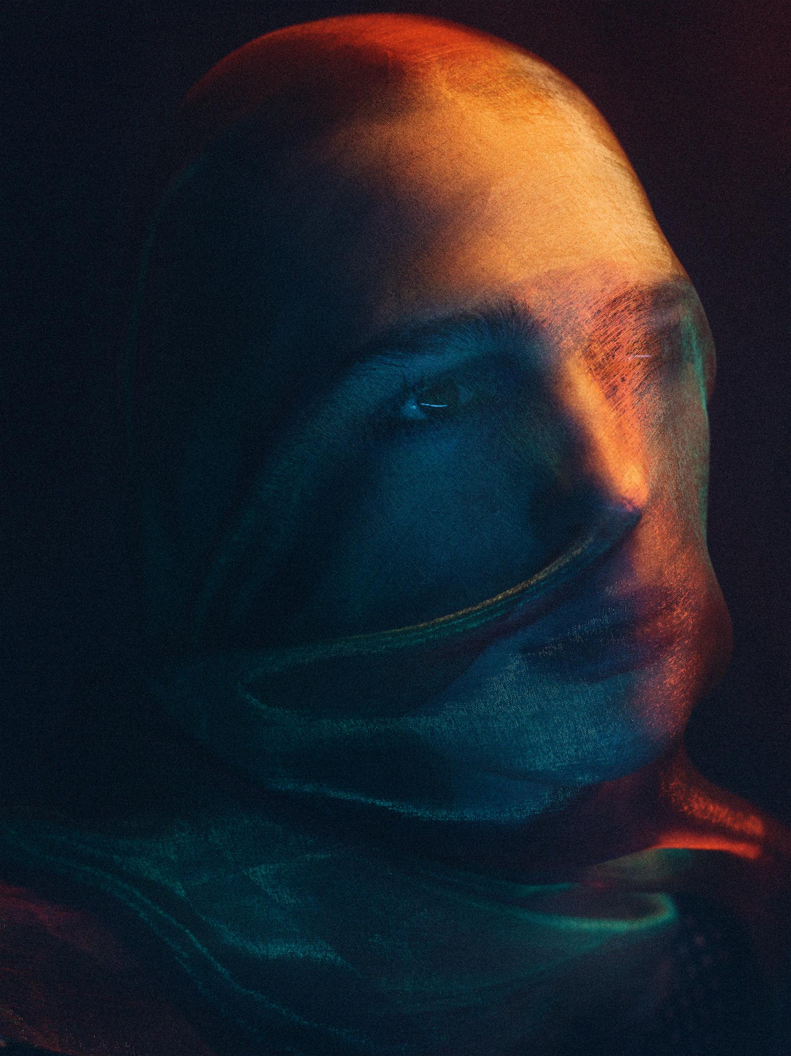 A person wearing a full-face mask, with only their eyes visible, in a dark and ominous setting.