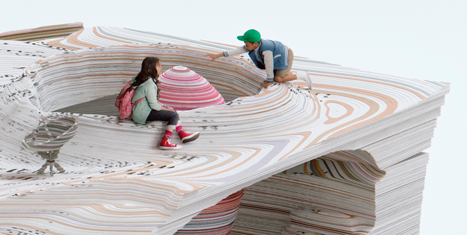 A young girl and a boy are sitting on a large, colorful, 3D-printed, wavy, abstract sculpture, surrounded by books and papers.