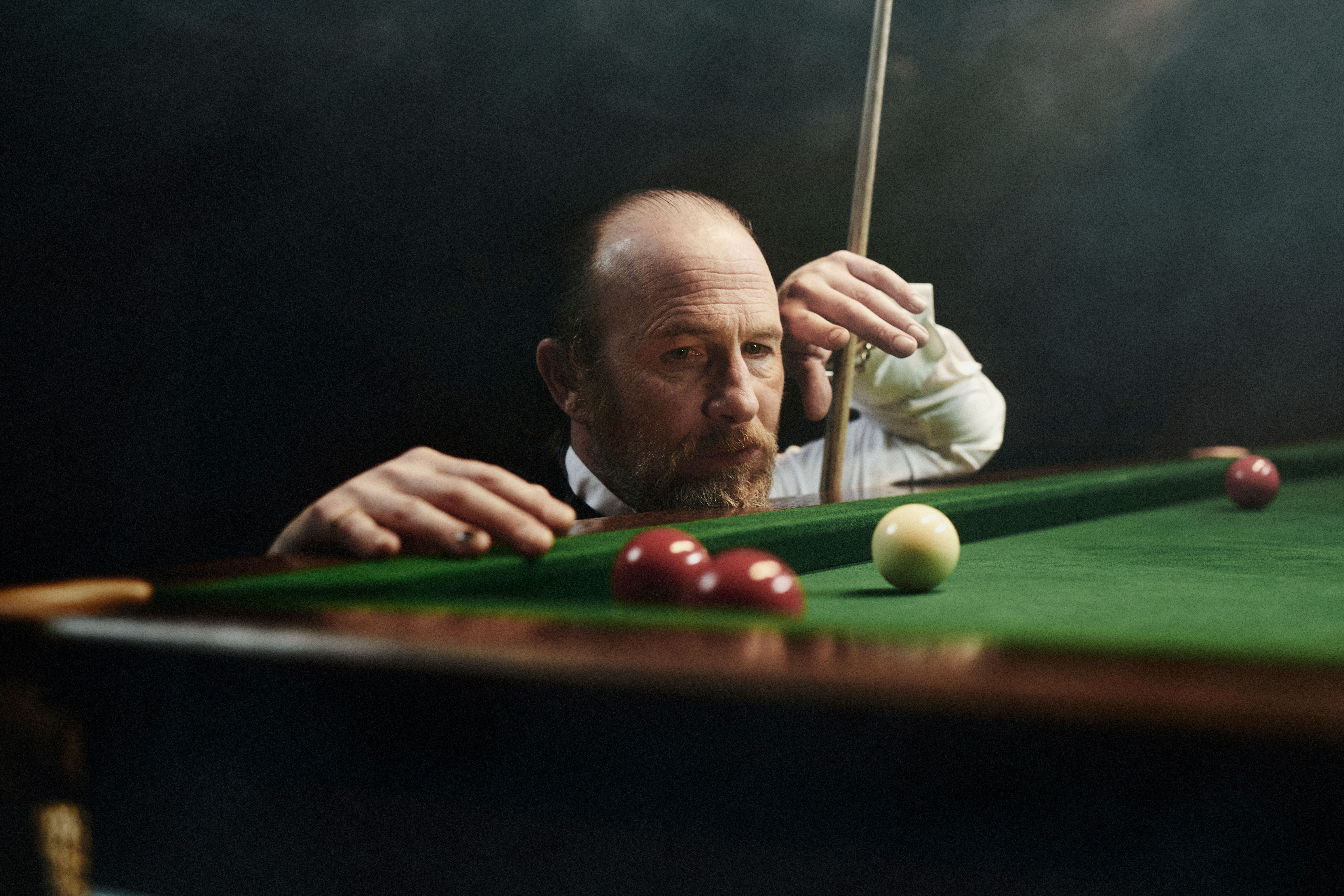 LOUIS-JACK snooker film player paul kaye looking at billiards balls with cue in hand